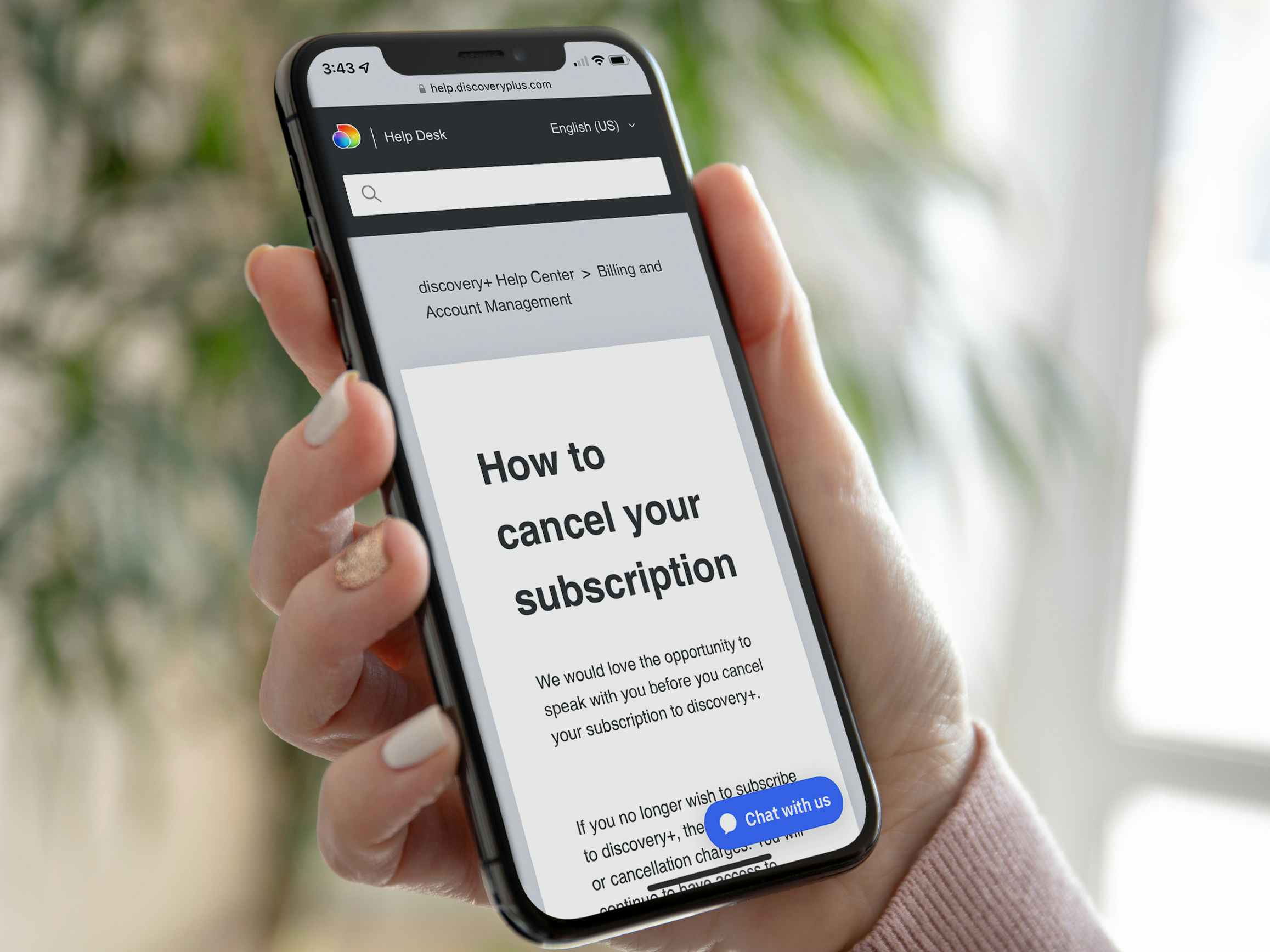 A person holding a phone displaying a Discovery Plus webpage about cancelling a Discovery Plus subscription