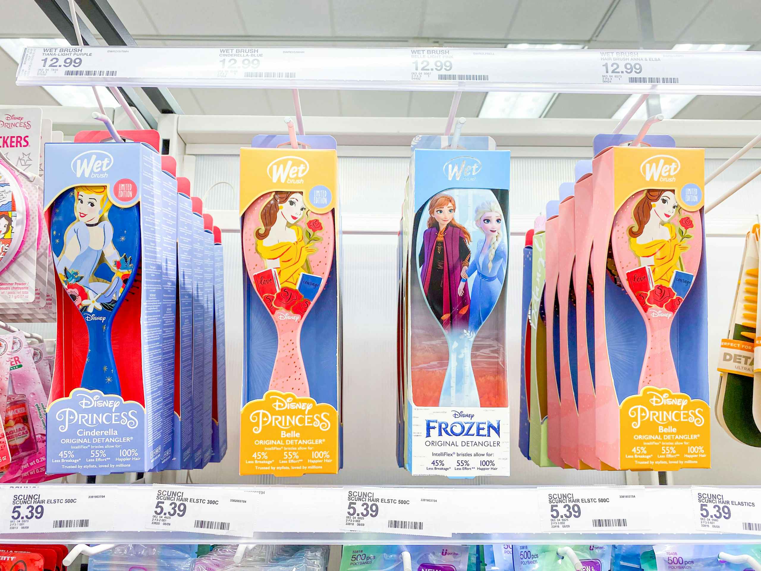 row of four disney princess wet brushes hanging on shelf at target