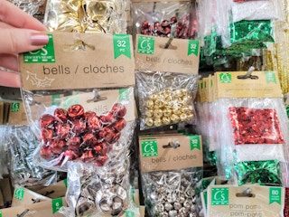 hand holding a pack of red small craft bells