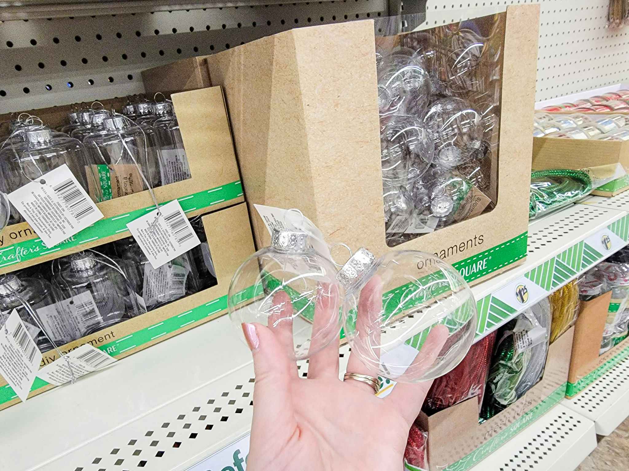 hand holding clear christmas ornaments