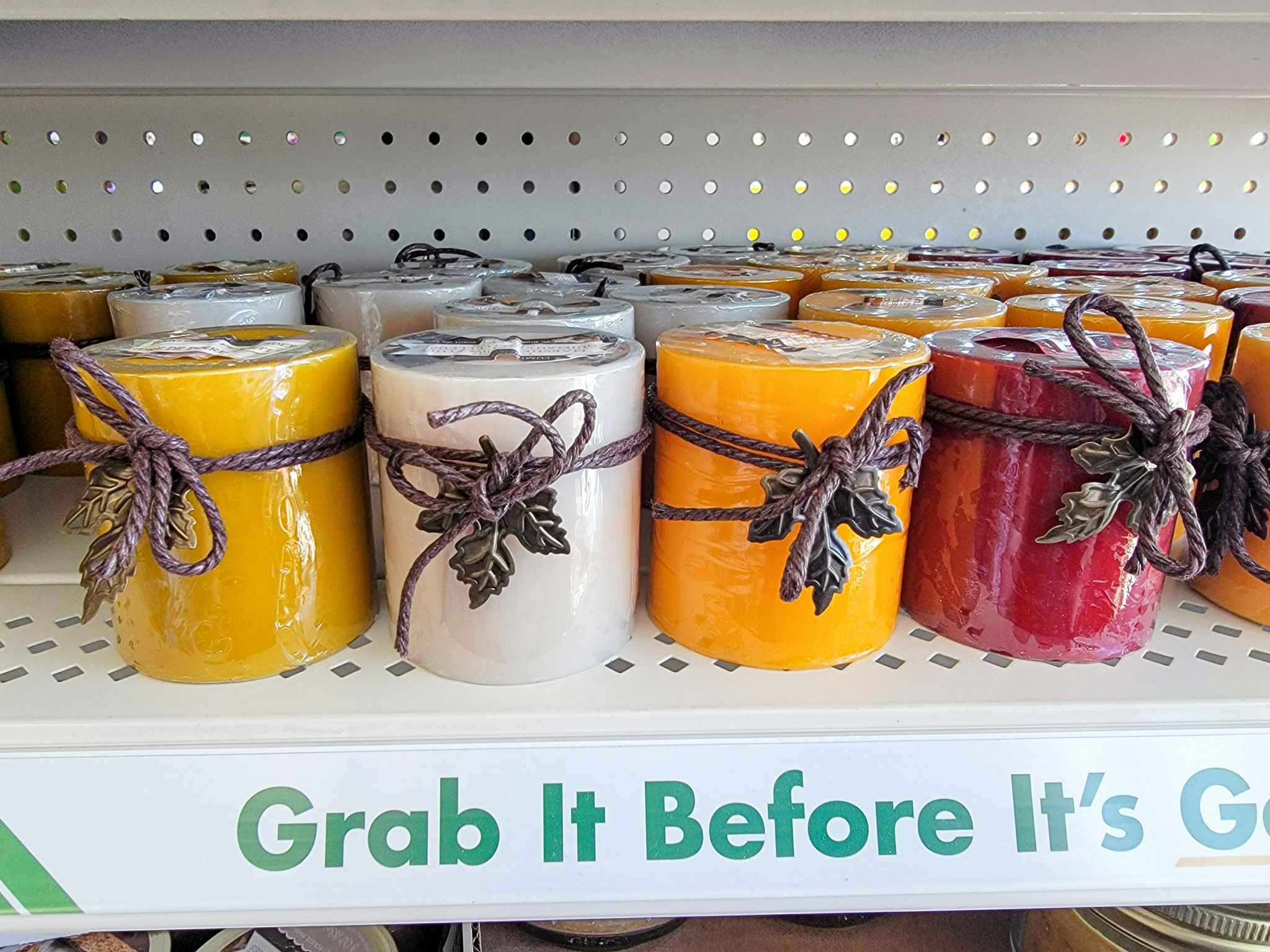 fall colored/scented candles on a shelf
