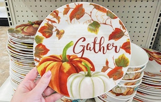 hand holding a small dish that says gather with pumpkins on it