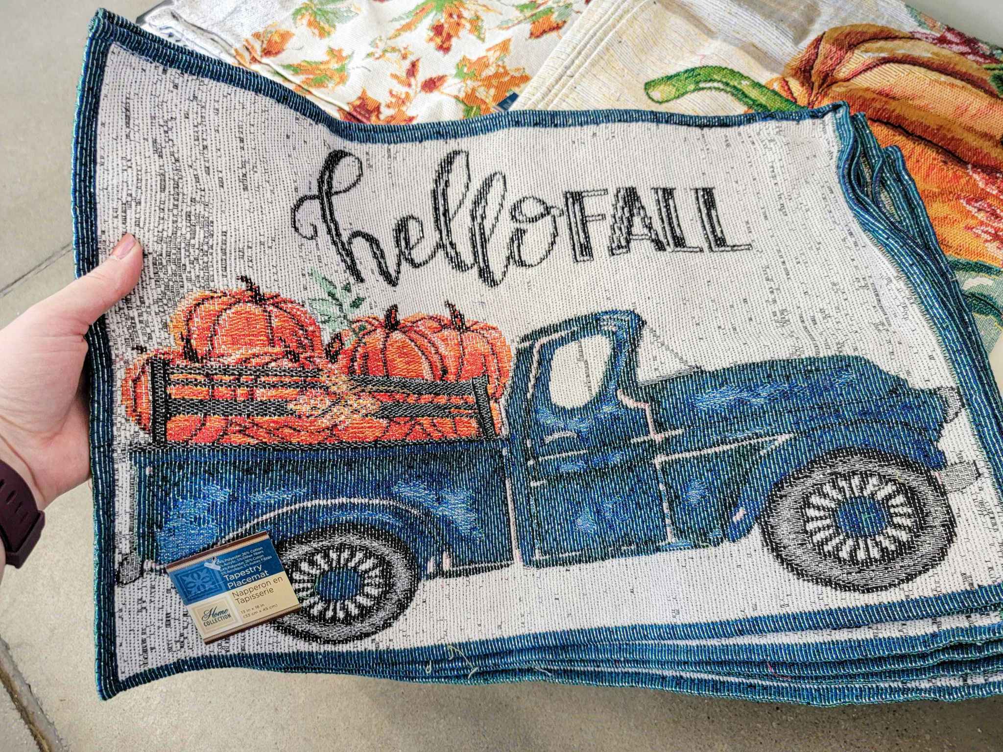 a stack of placemats that says hello fall with a blue truck on it with pumpkins in the bed