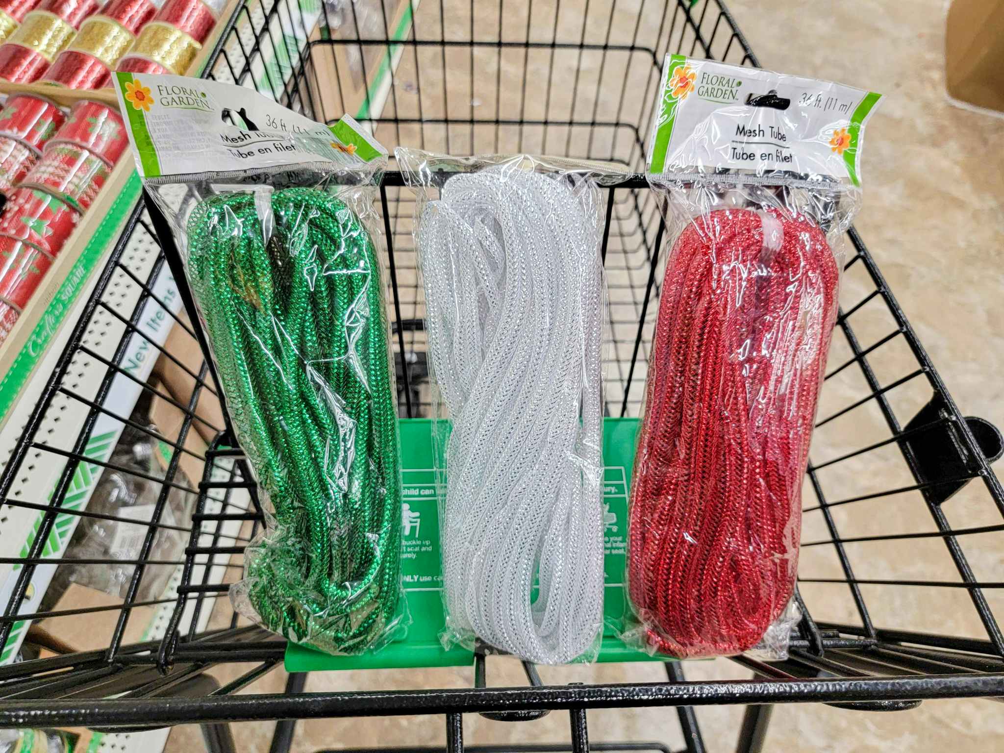 green, white, and red mesh tubing for crafts in a cart
