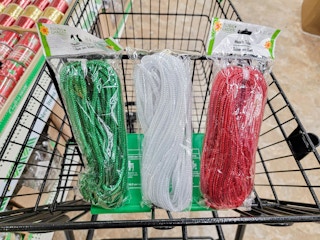 green, white, and red mesh tubing for crafts in a cart
