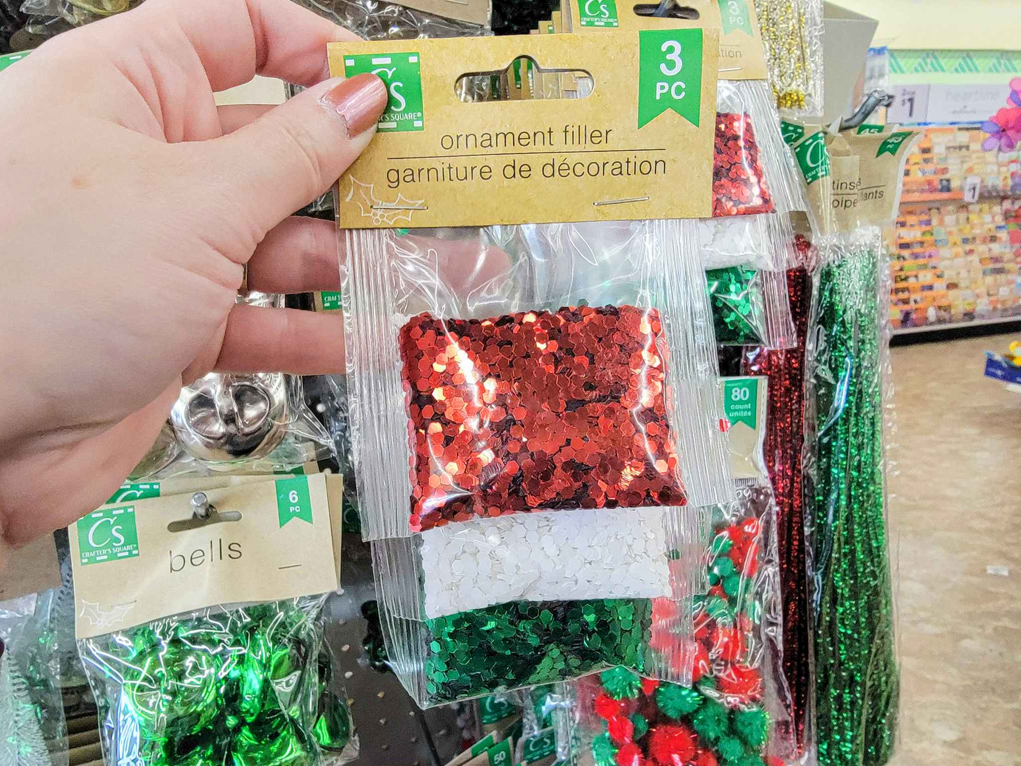hand holding ornament filler in christmas colors