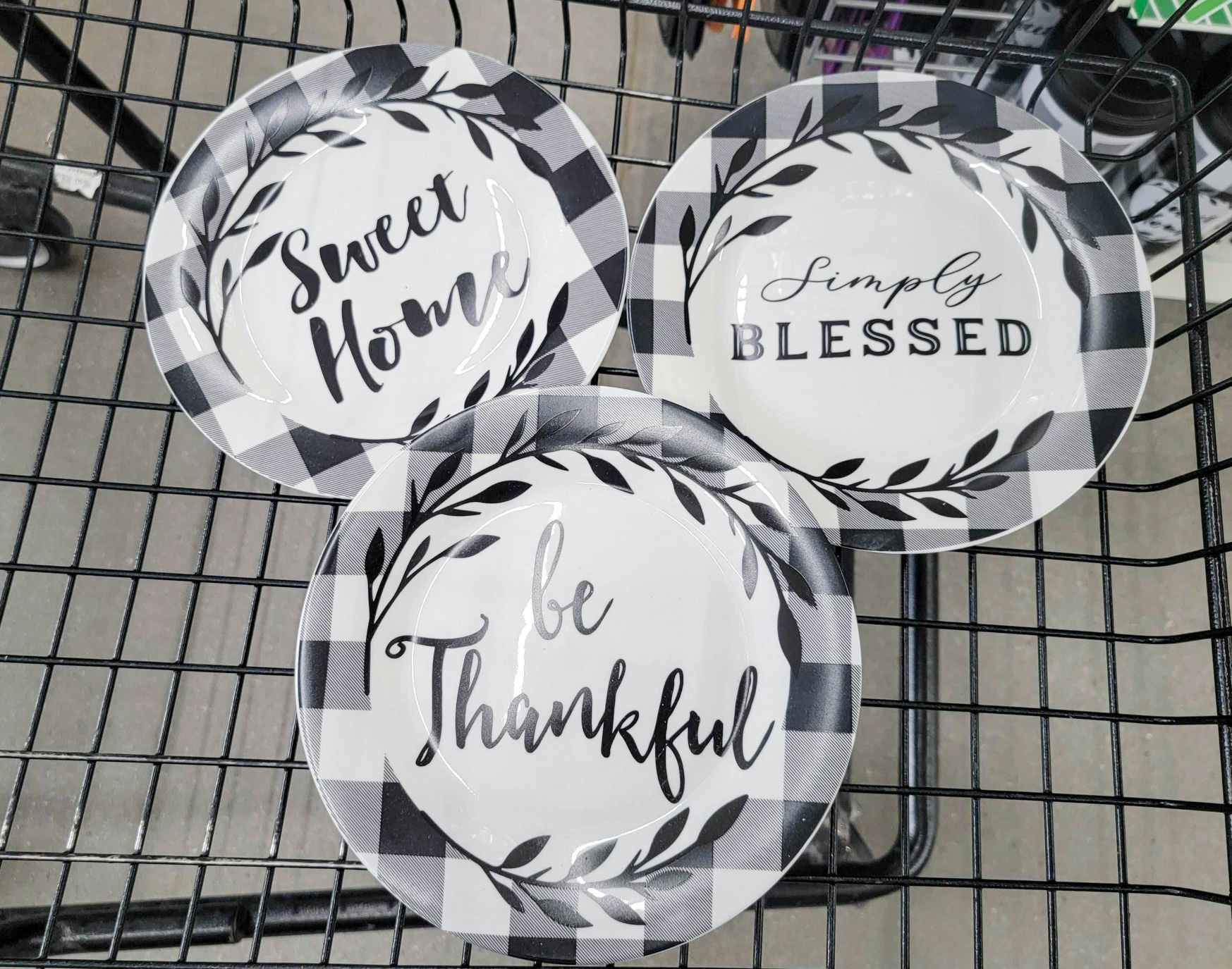 3 buffalo plaid plates in a cart, one says sweet home, one says simply blessed, one says be thankful