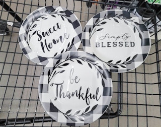 3 buffalo plaid plates in a cart, one says sweet home, one says simply blessed, one says be thankful
