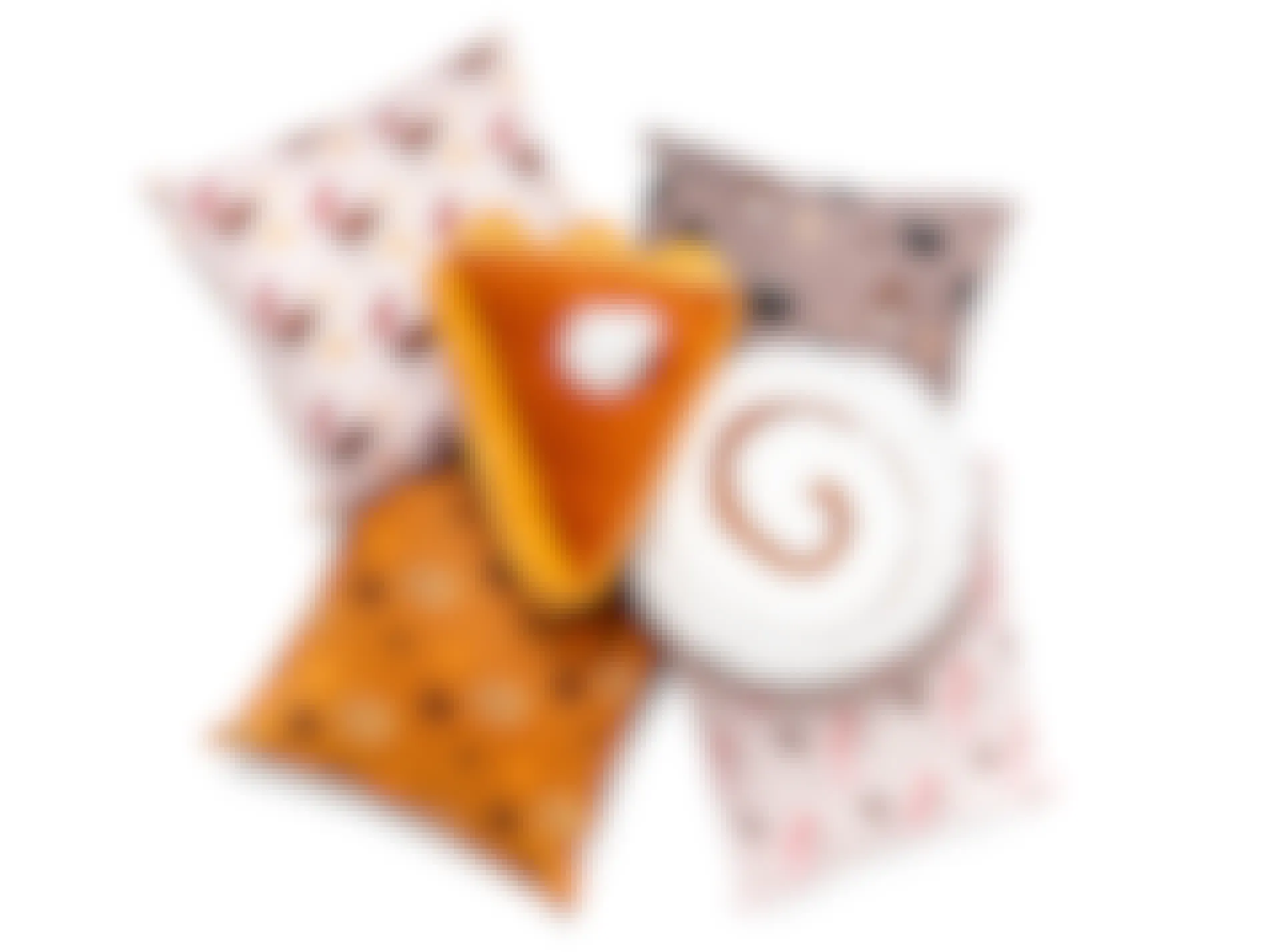 A set of six Dairy Queen scented pillow with one shaped like a pumpkin pie slice and another shaped like a cinnamon roll.