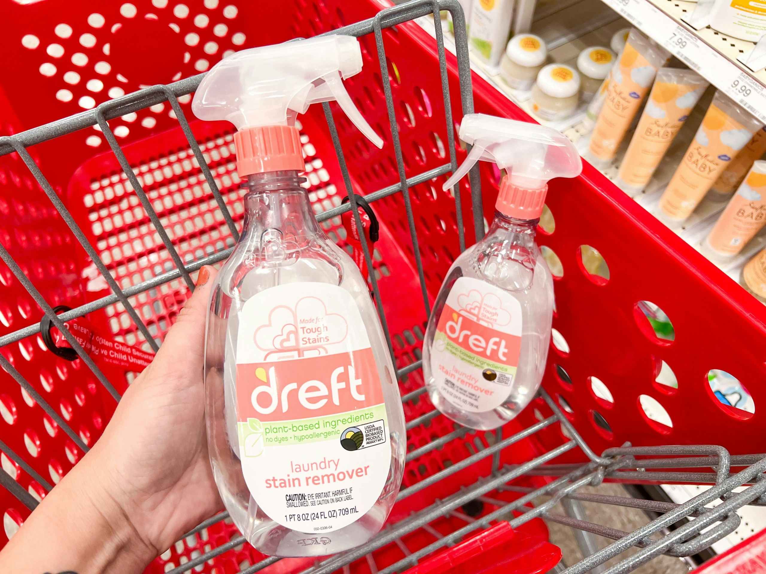 hand holding a bottle of dreft laundry stain remover over a target cart