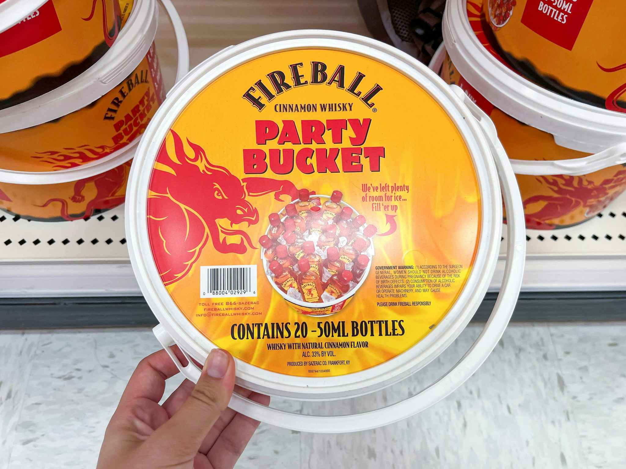 hand grabbing a fireball party bucket off a shelf at target