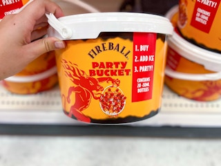 hand grabbing a fireball party bucket off a shelf at target