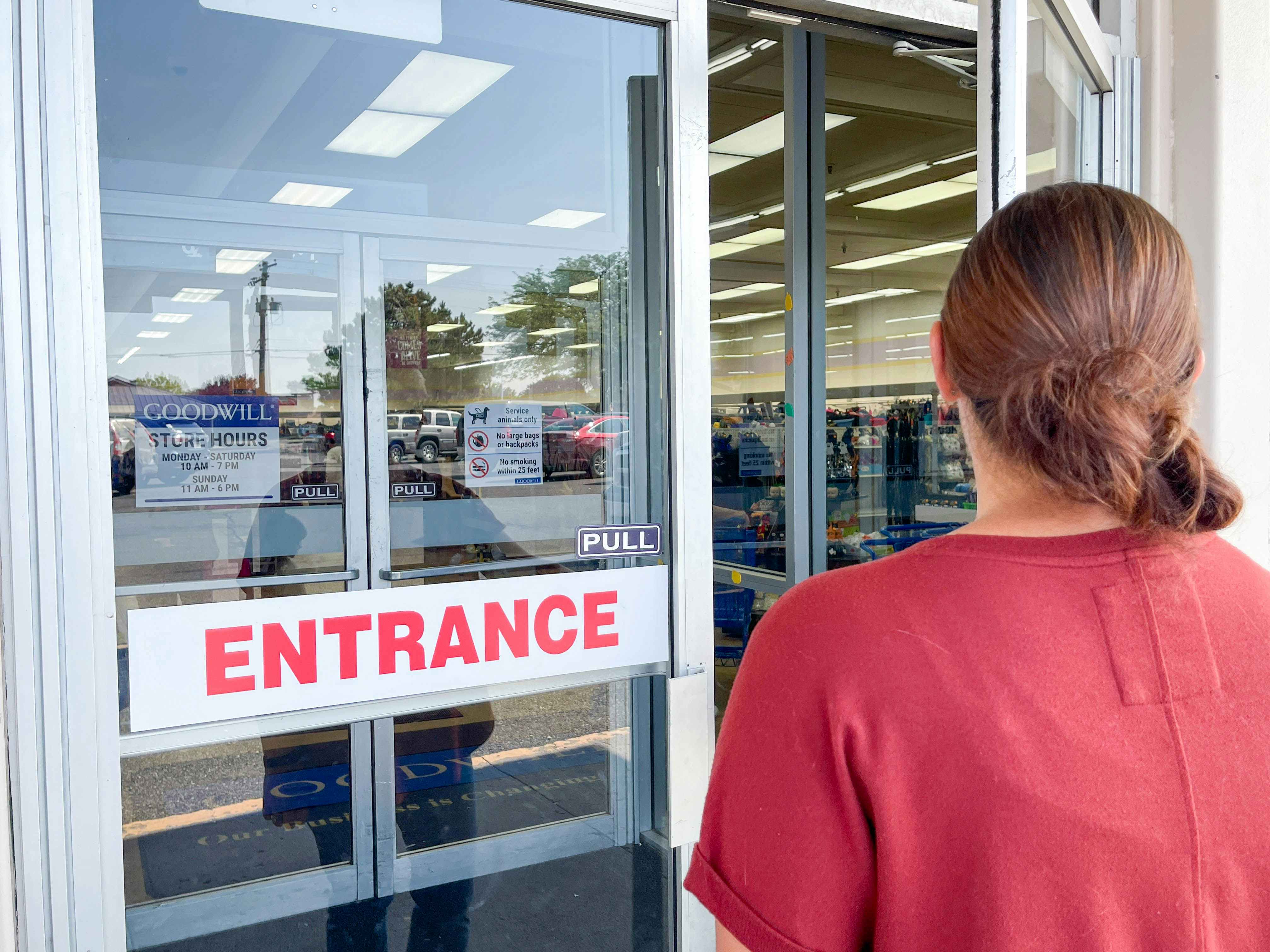 a woman going into entrance of goodwill