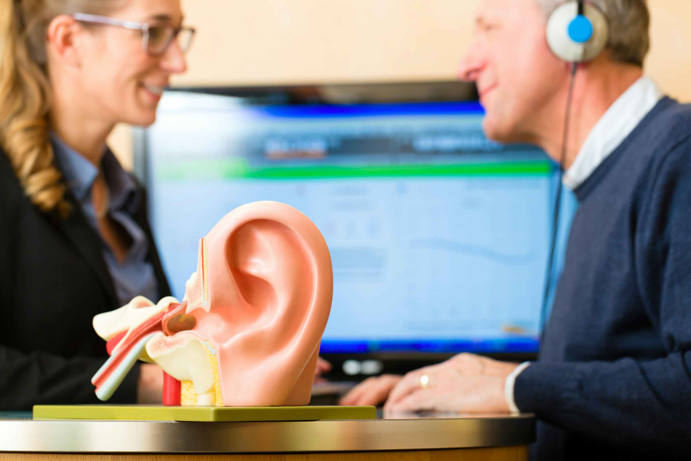 A female doctor gives a male patient a hearing test for a hearing aid