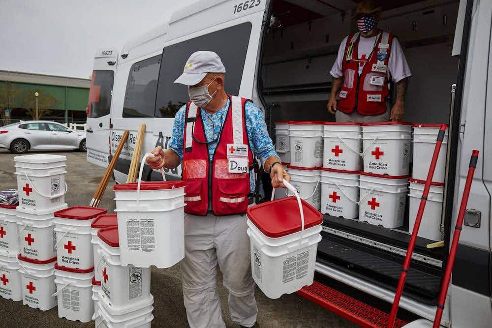 man volunteering for the red cross and carrying buckets