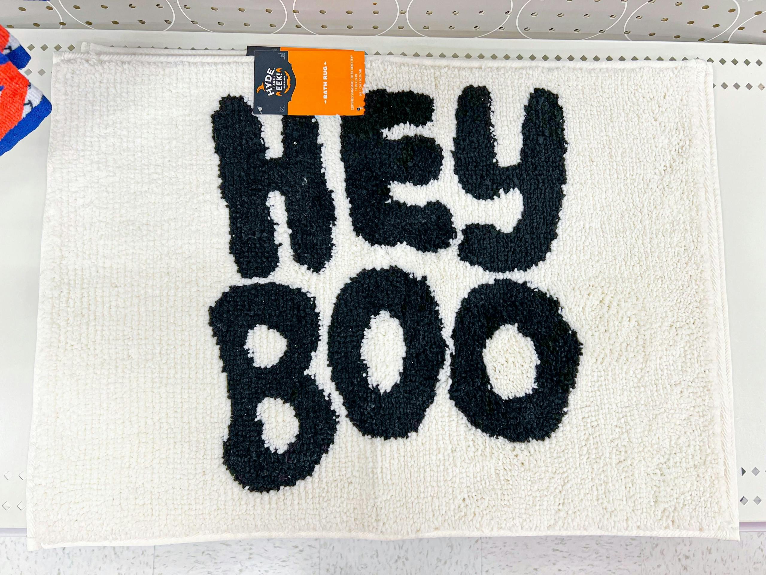 A bath mat that says "Hey Boo" on a Target shelf.