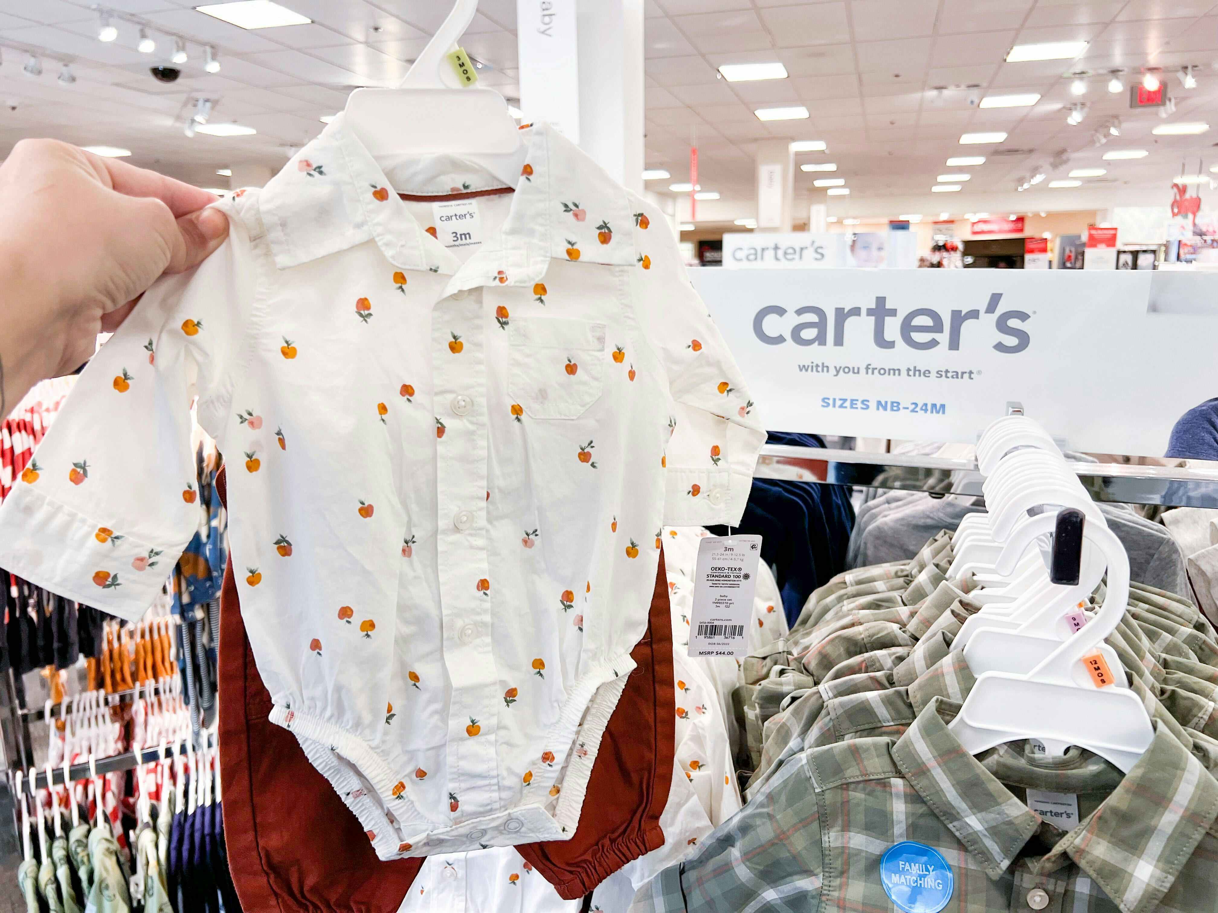 hand holding up clearance carter's outfit at jcpenney