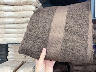 someone grabbing bath towels on shelf at kohls