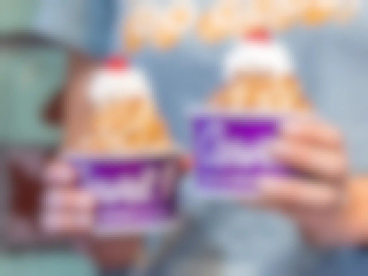 person holding two carvel ice cream sundaes
