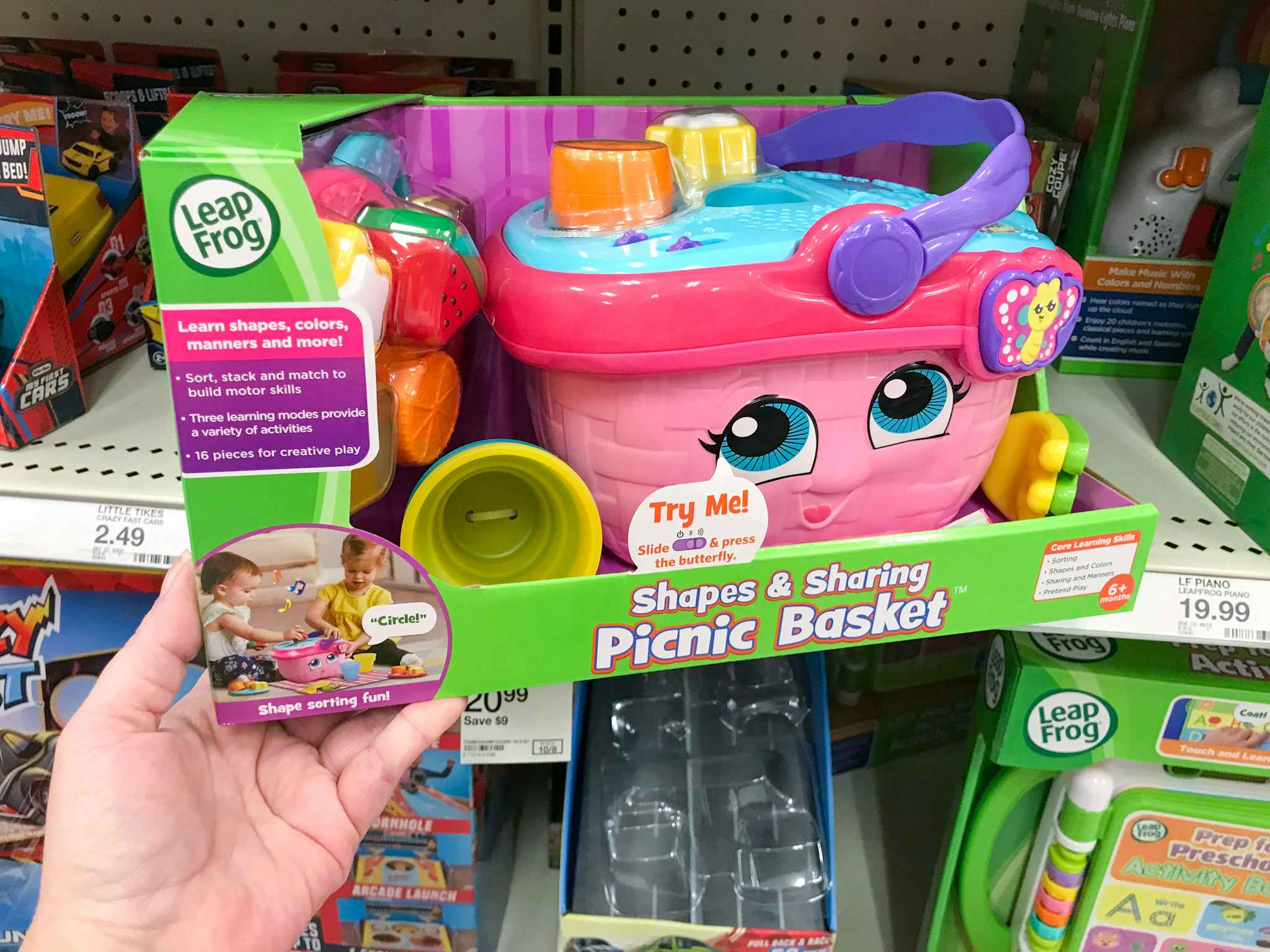 hand grabbing a leapfrog shapes and sharing picnic basket off a target shelf