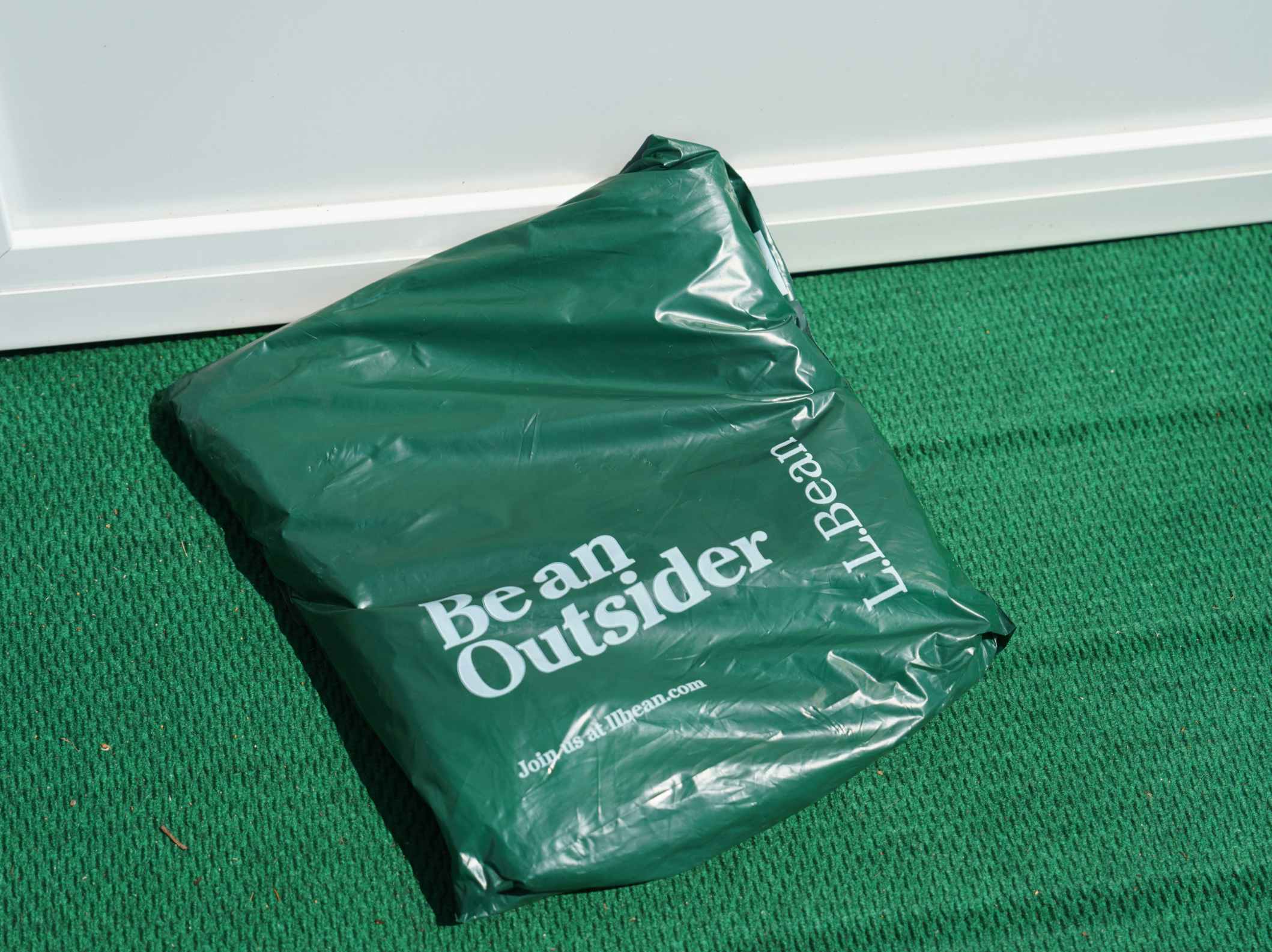 An LL Bean package sitting outside of a front door.