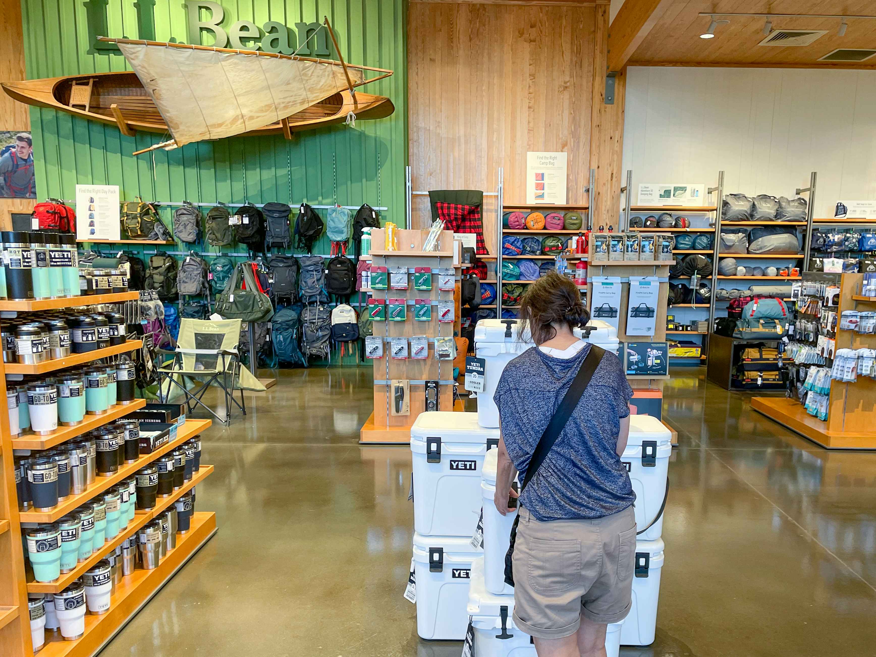 A woman looking at Yeti coolers on display inside L.L.Bean.