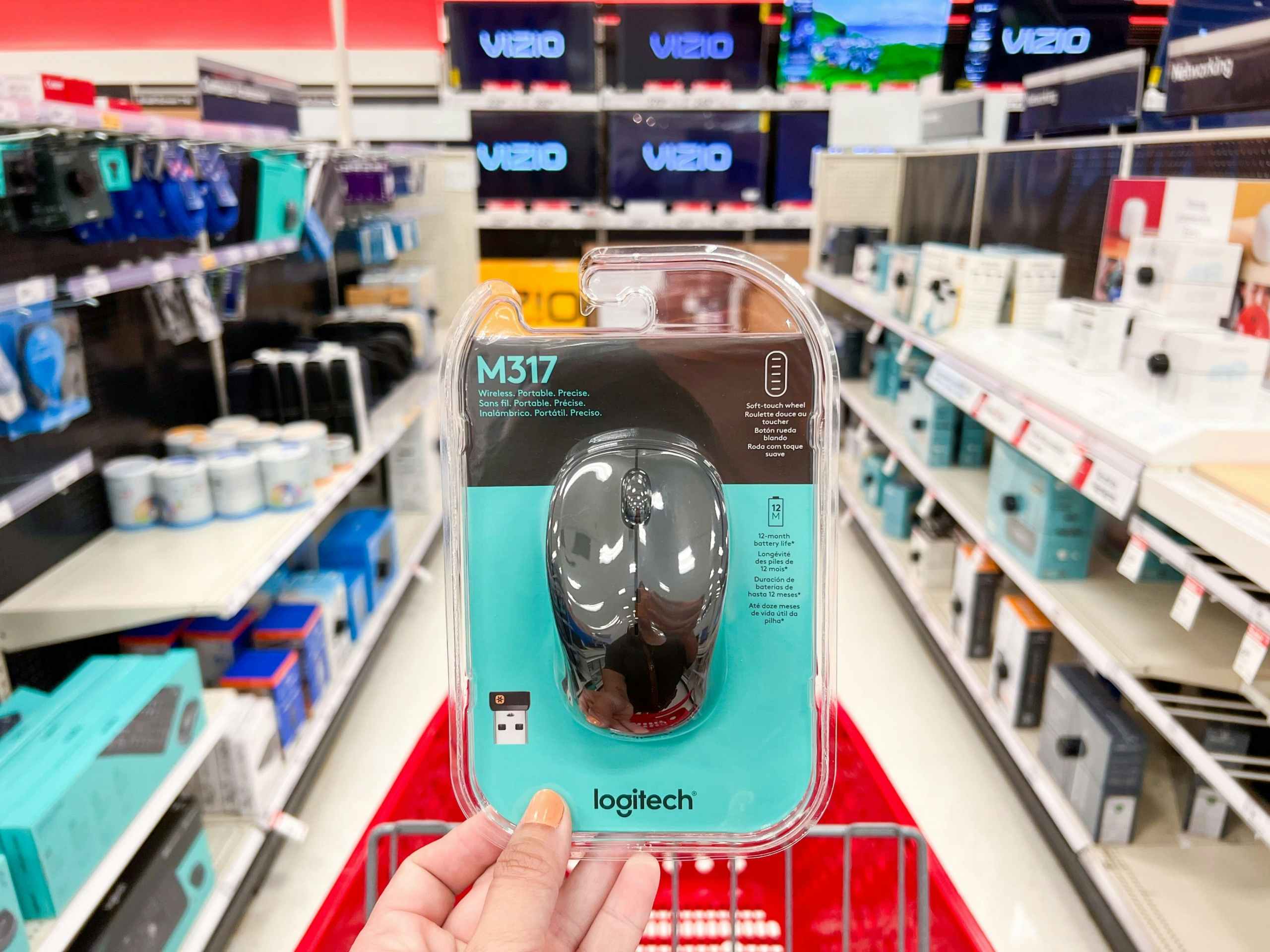 hand holding black logitech mouse in front of cart and aisle