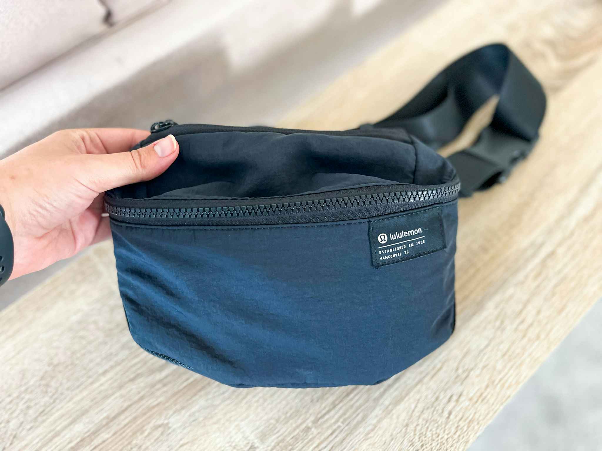 hand holding up corner of lululemon belt bag