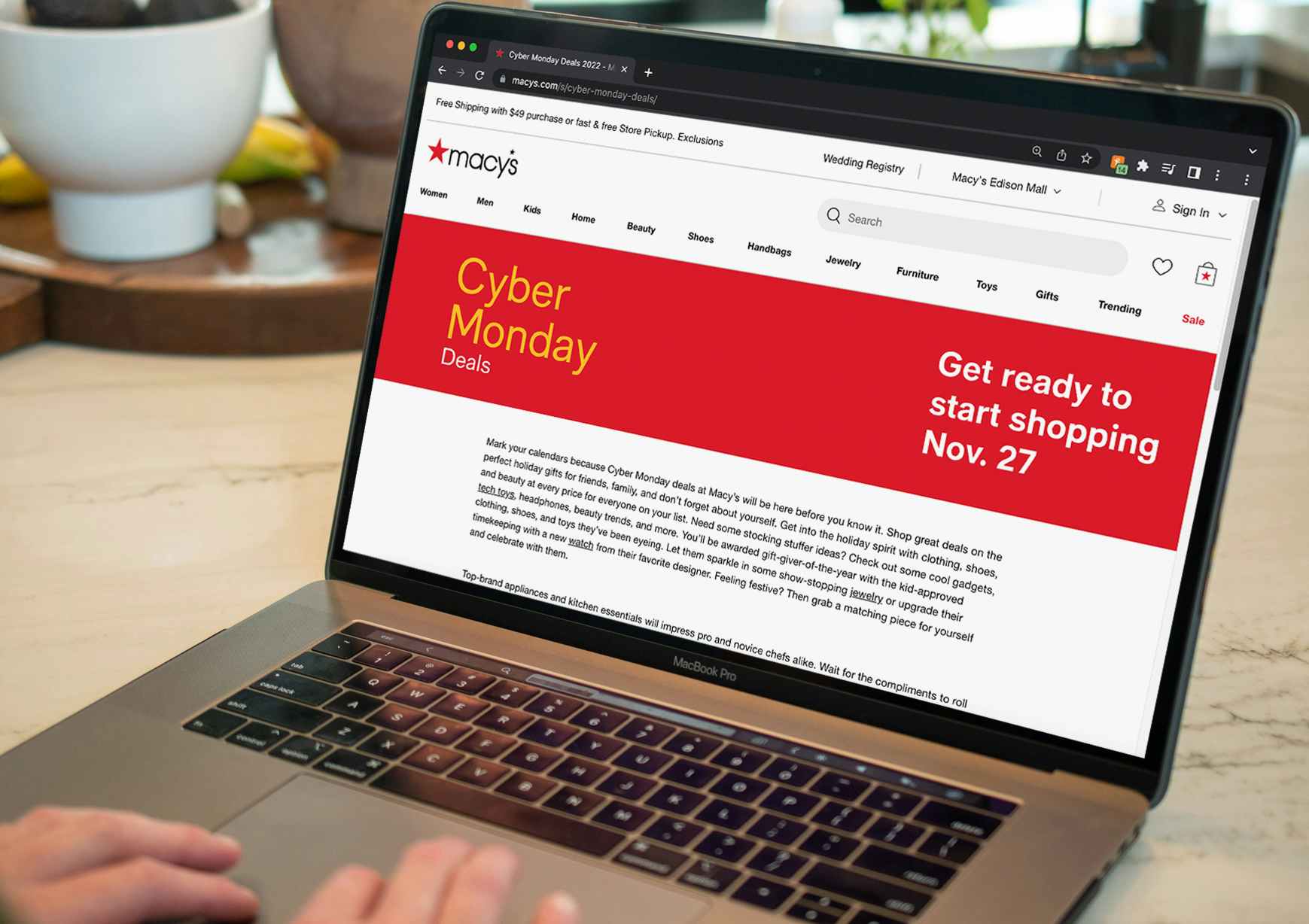 A person using a laptop displaying the Macy's website page for Cyber Monday deals.