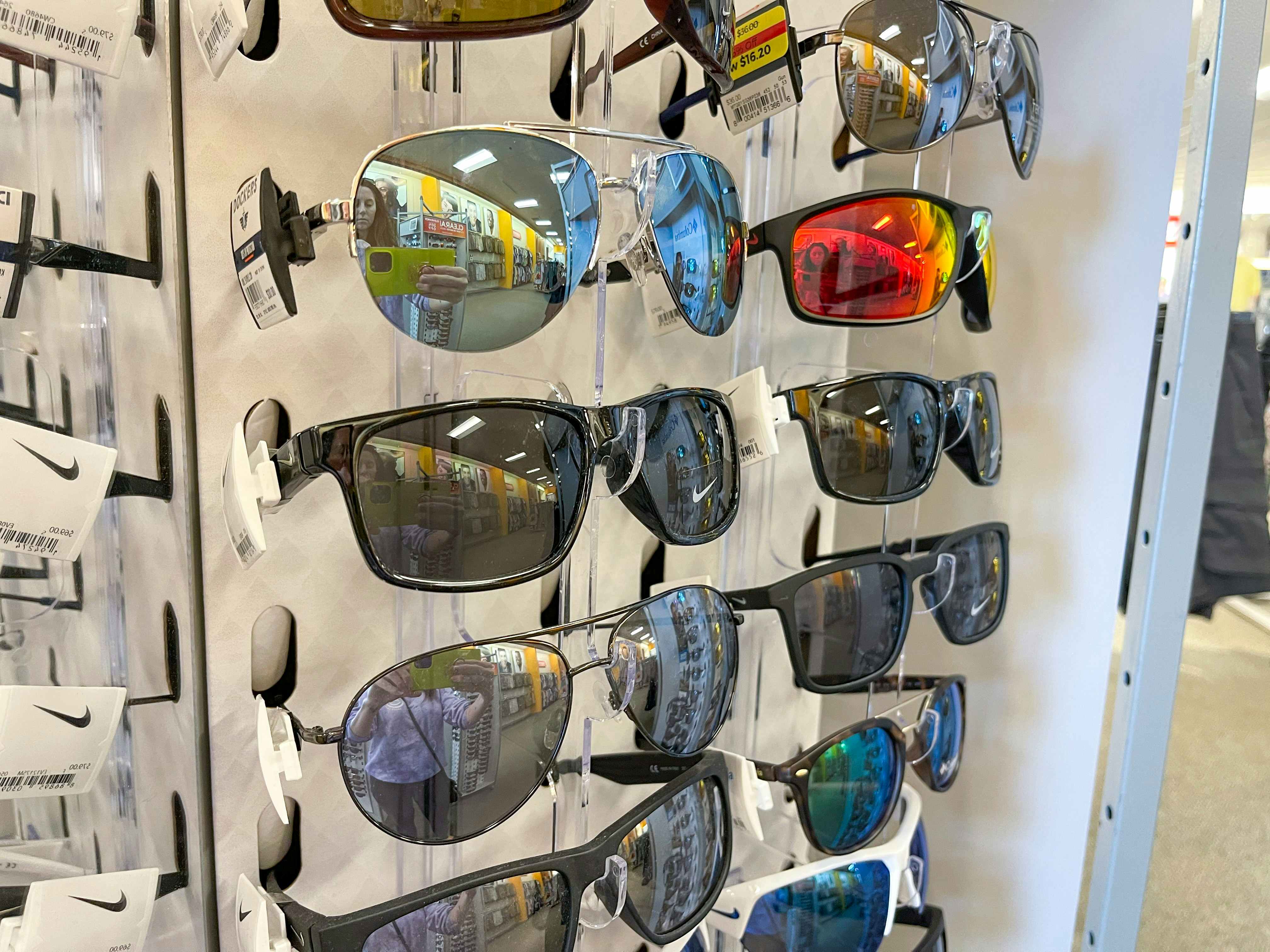 A variety of Nike sunglasses sitting in a sunglass stand at the store.