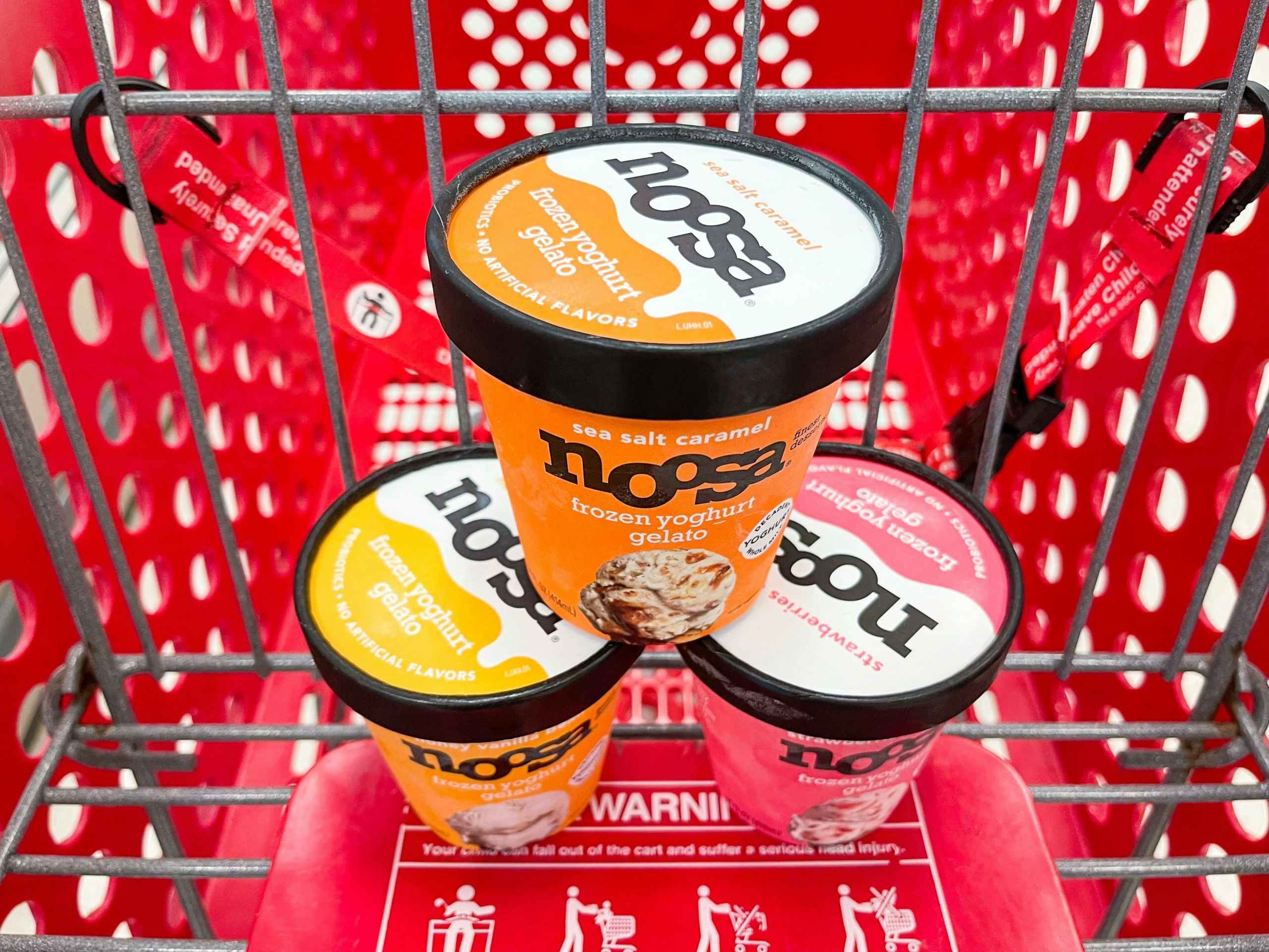 A variety of Noosa Frozen Yoghurt Gelato making a pyramid in a shopping cart.