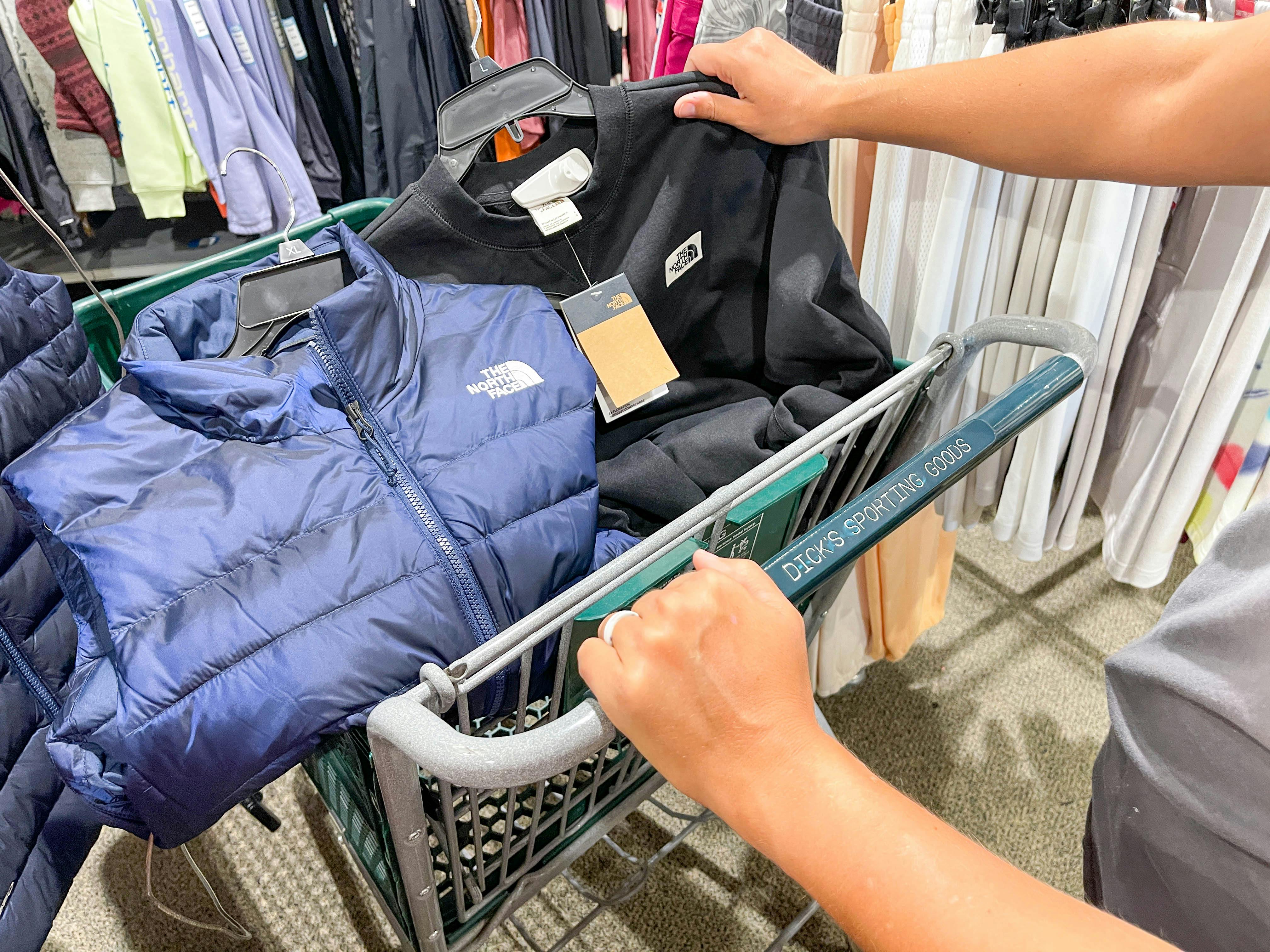 a dicks shopping cart with north face outerwear in basket
