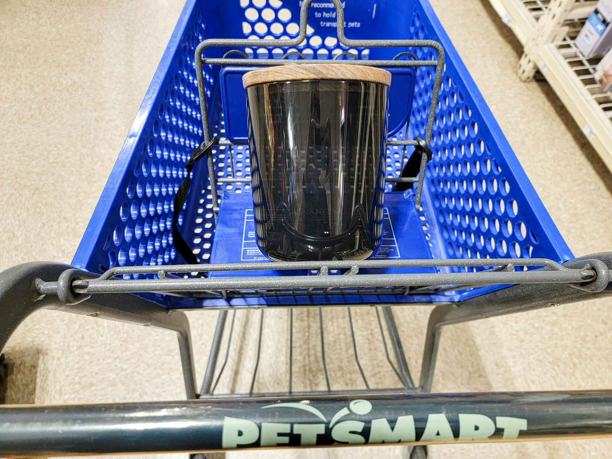 a black dog treat container with a wooden lid in a cart