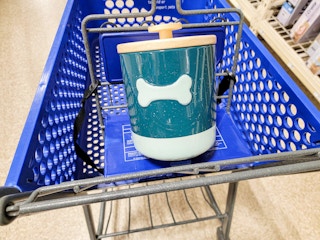 a blue dog treat holder with a teal bone on it in a cart