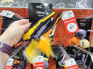 hand holding a 3-pack of broom cat toys from hocus pocus