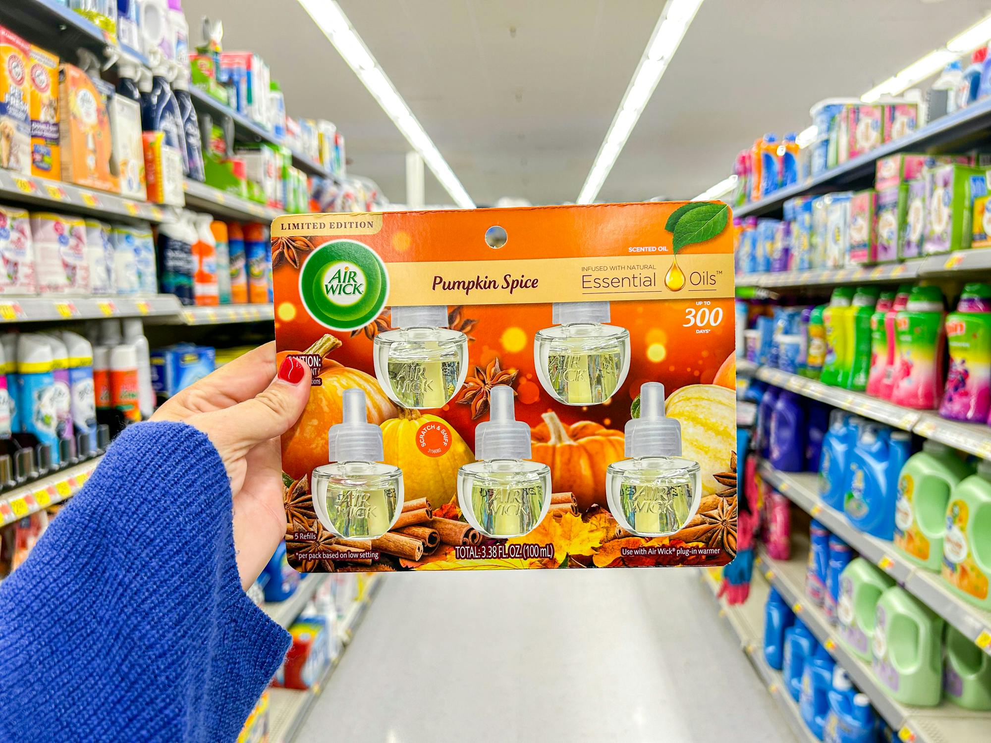 a person holding up pumpkin spice air wick in walmart