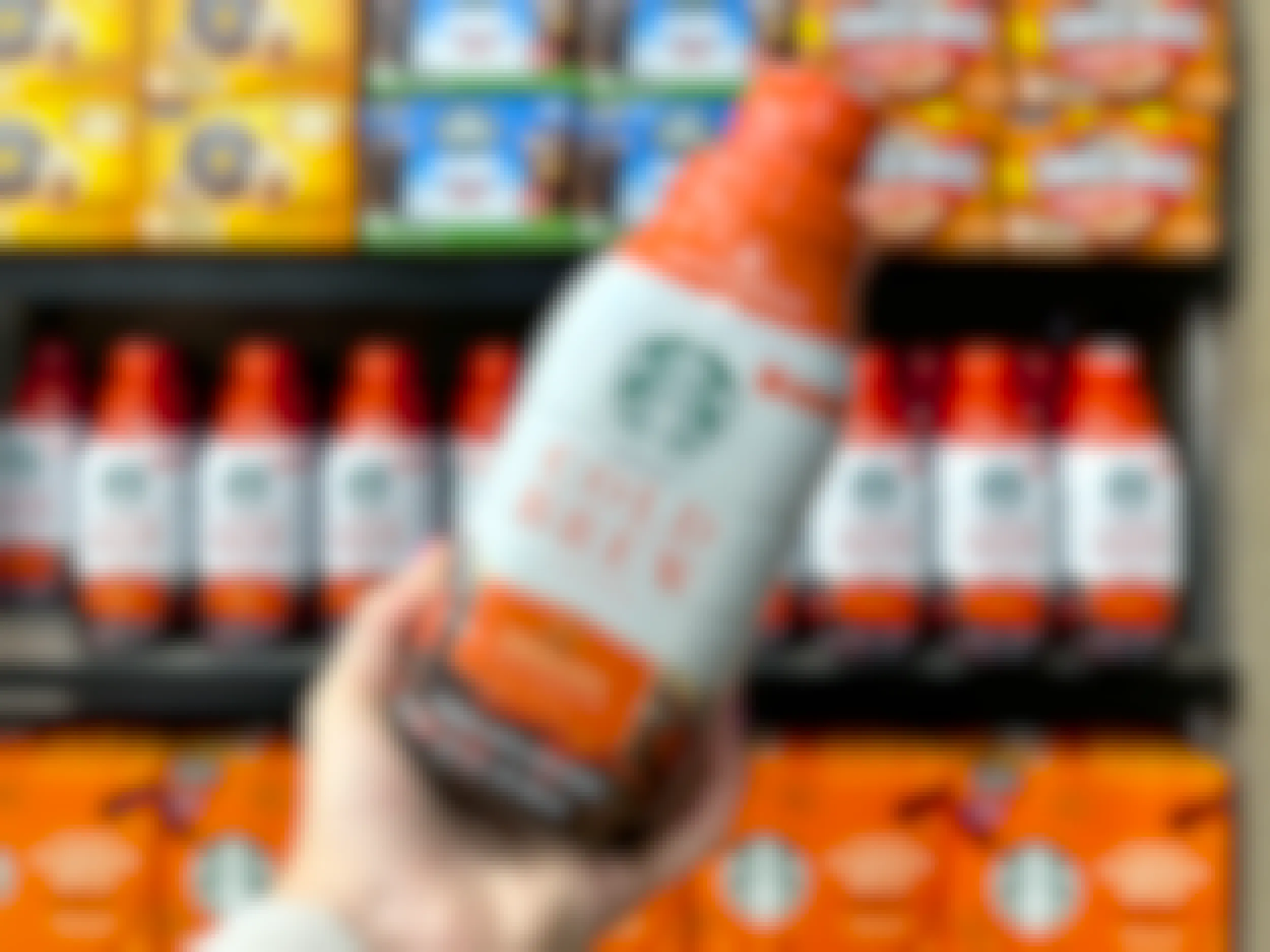 hand holding bottle of starbucks pumpkin spice cold brew near other fall products in jewel osco