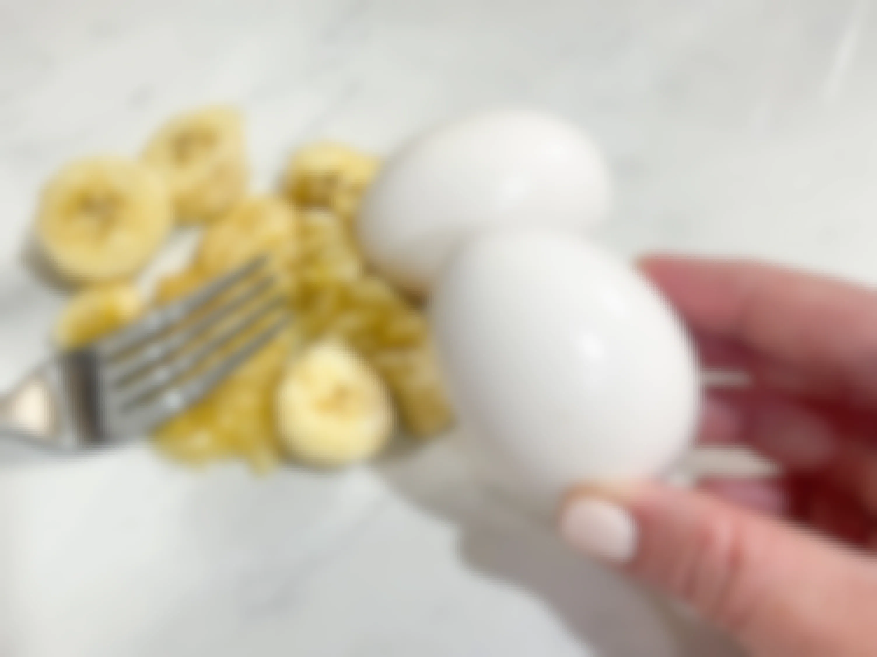 a person holding an egg in front of smashed bananas