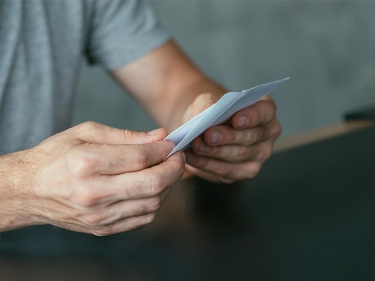 man opening business letter or check