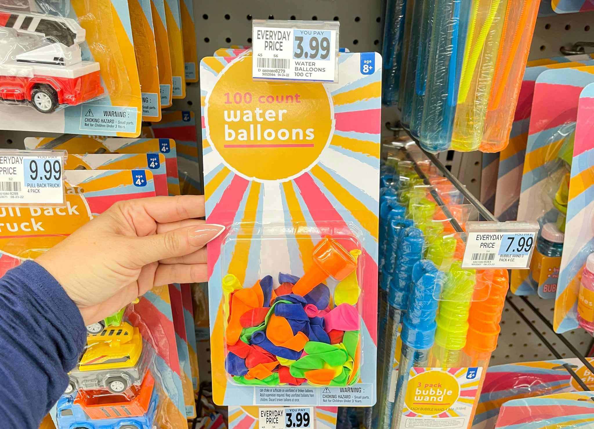 hand holding water balloon package under price tag