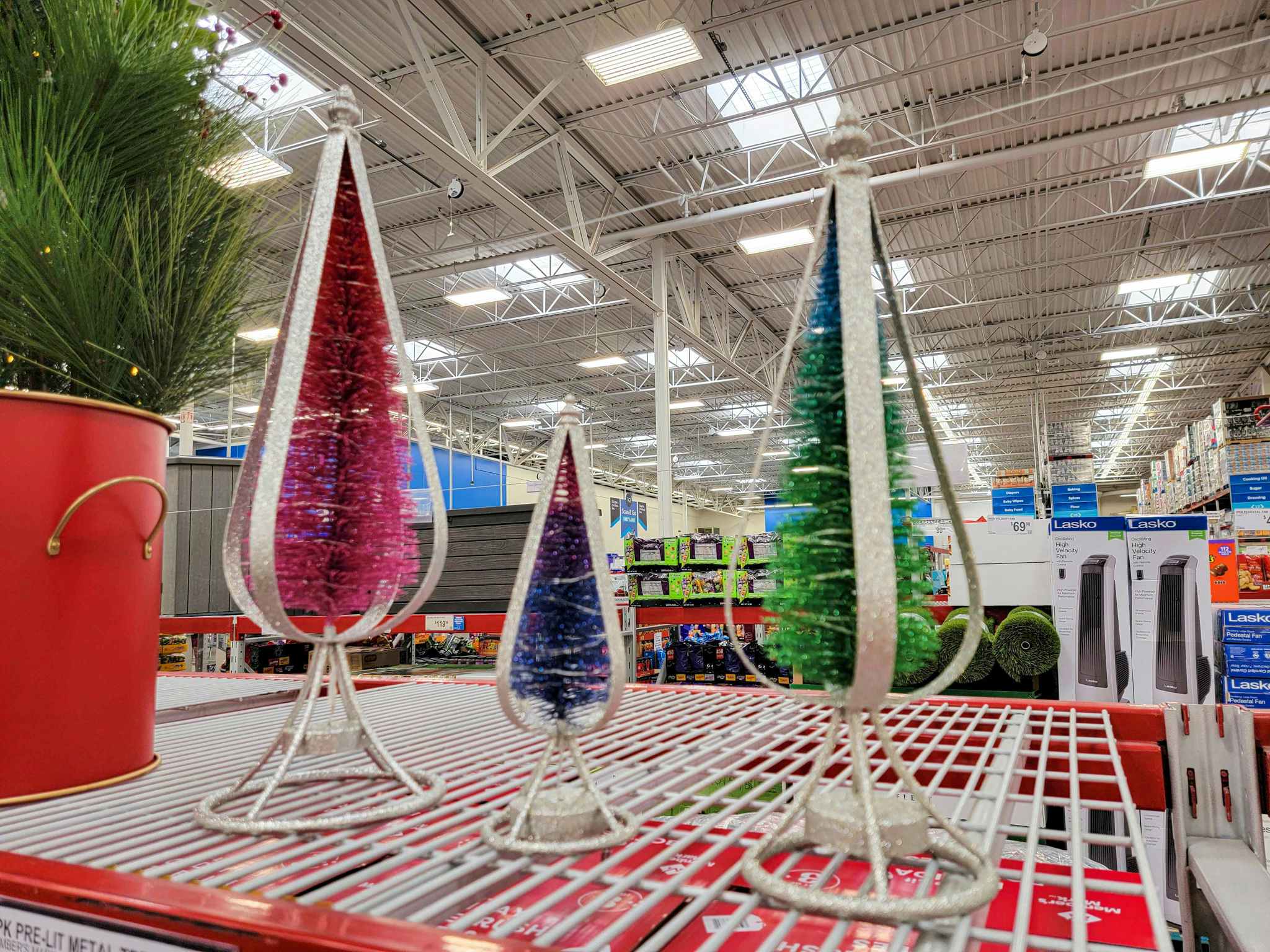 3 bottle brush style christmas trees displayed on a shelf