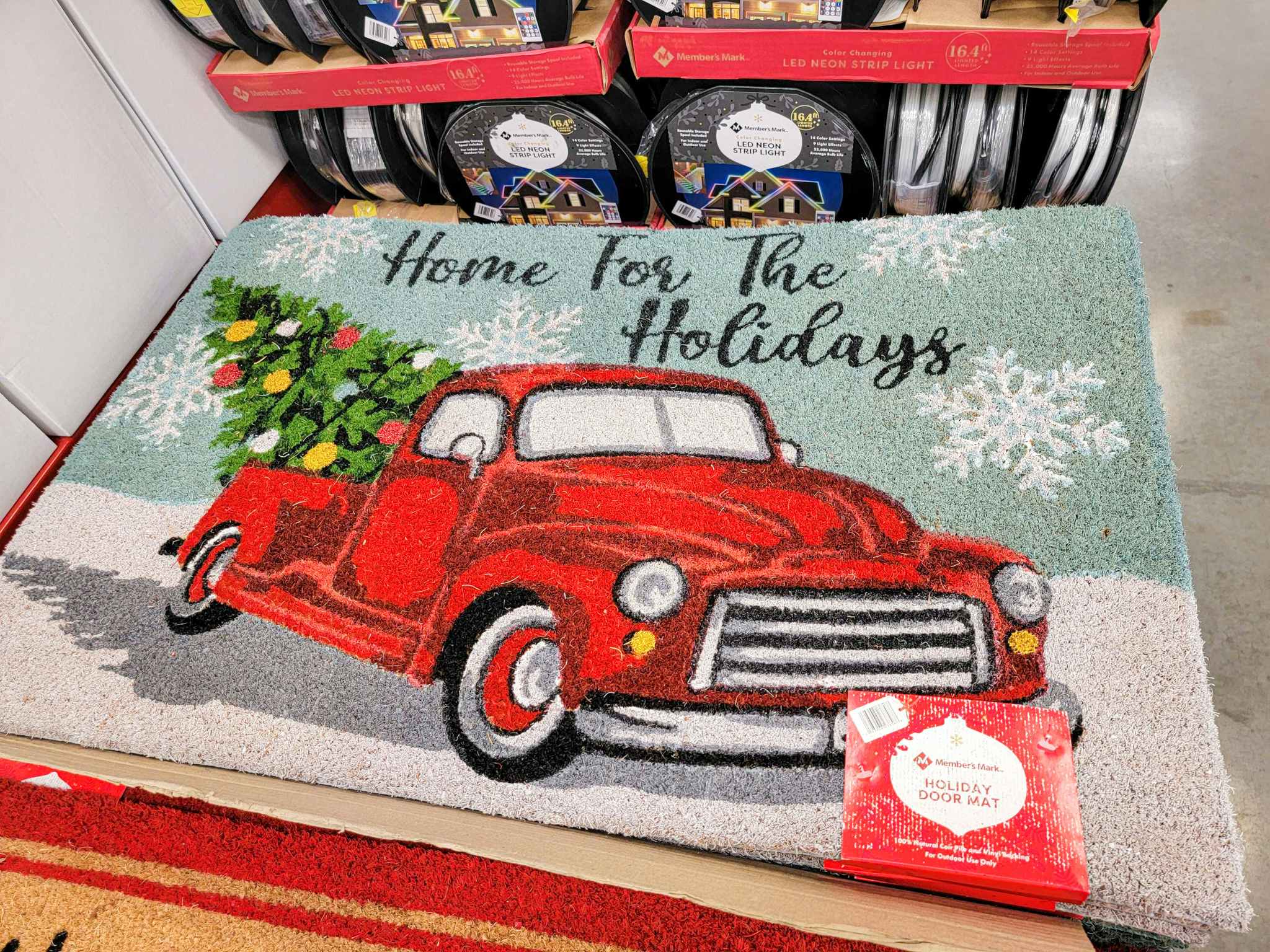 outdoor rug with a red truck that says home for the holidays