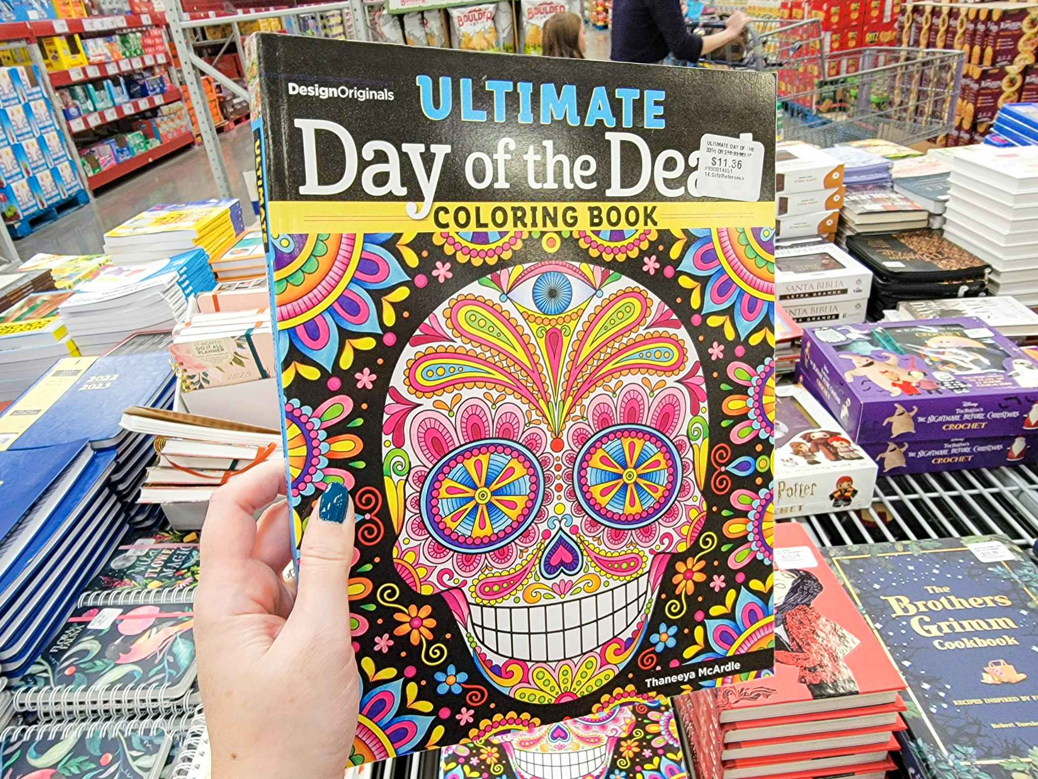 hand holding a day of the dead coloring book