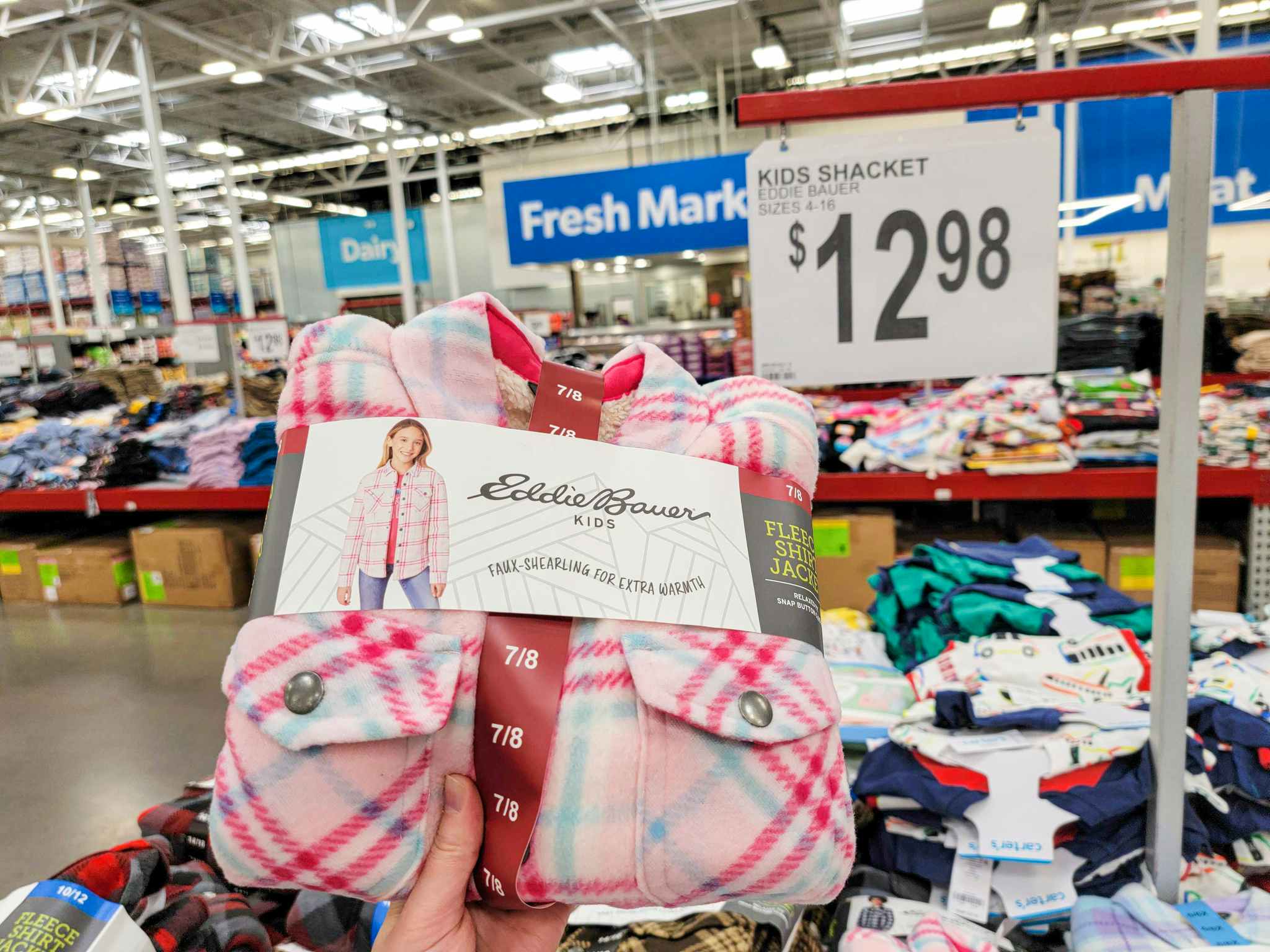 hand holding a pink plaid eddie bauer kids shacket by the price sign for 12.98