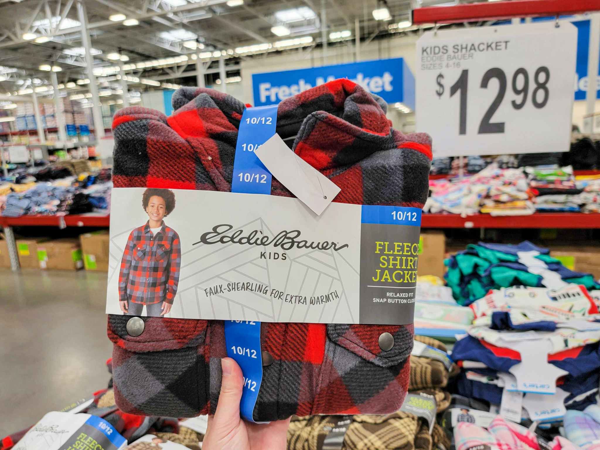 hand holding a red & grey buffalo plaid kids eddie bauer shacket by the price sign for 12.98