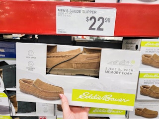 hand holding a pair of tan eddie bauer slippers