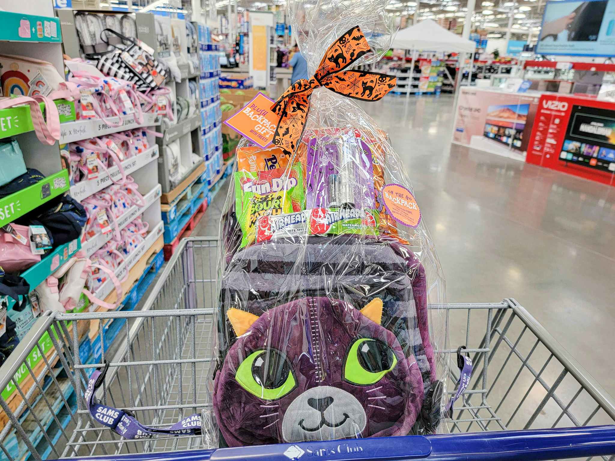 a purple halloween plush cat backpack set in a cart