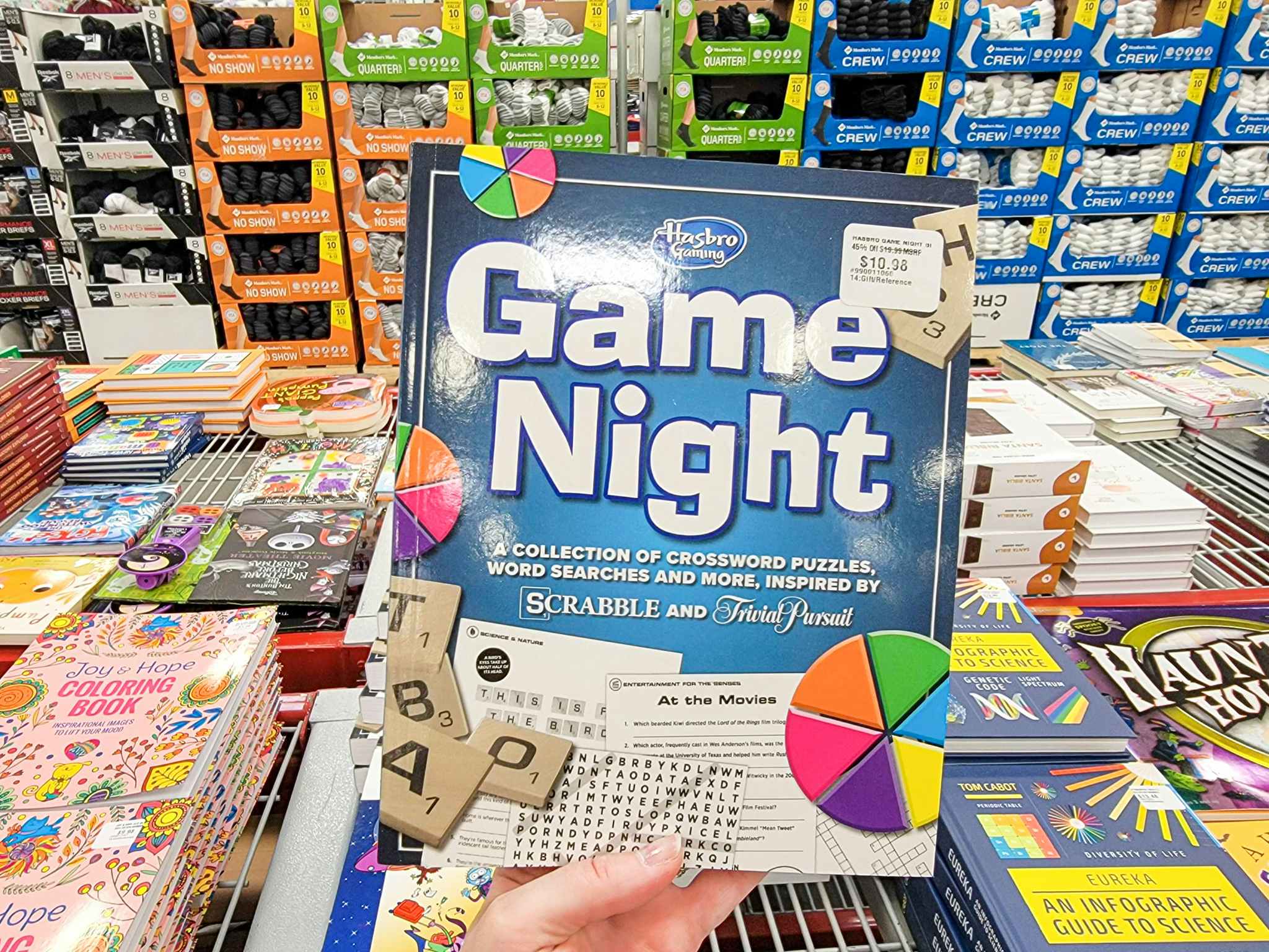 hand holding a hasbro game night book inspired by scrabble and trivial pursuit 