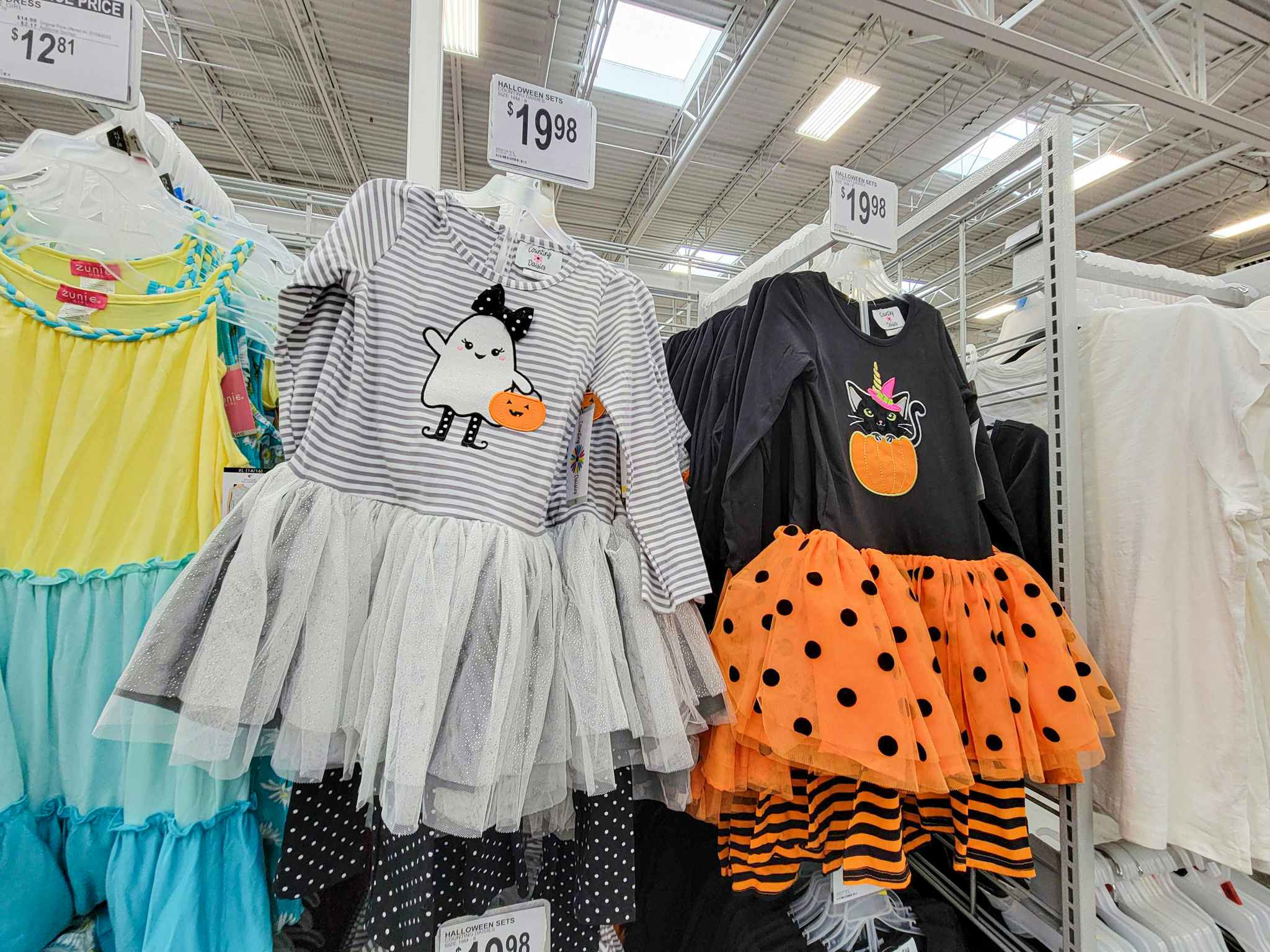 kids halloween dresses, left is grey with a ghost, right is black & orange with a cat in a pumpkin