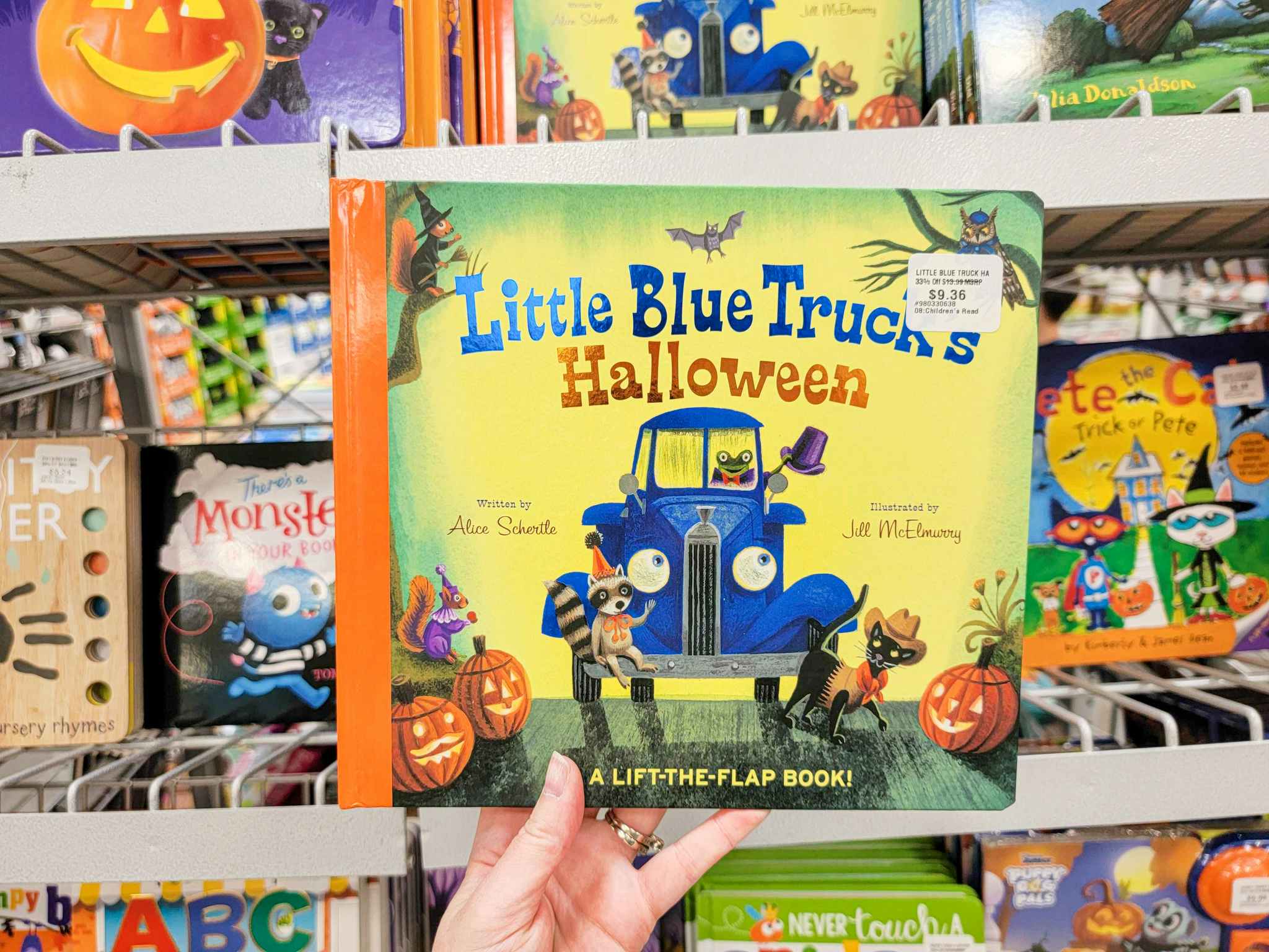hand holding a little blue truck halloween book